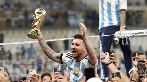 ليونيل ميسي يحتفل بكأس العالم مع منتخب الأرجنتين وسط الجماهير بعد فوزه في مونديال قطر 2022، رمز الإنجاز الرياضي والتاريخي.