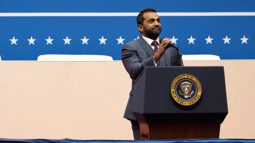 كاش باتيل، مرشح قيادة مكتب التحقيقات الفيدرالي، يتحدث من خلف منصة تحمل شعار الرئاسة، مع خلفية تضم نجوم حمراء وبيضاء زرقاء.