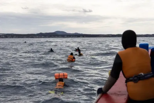 مجموعة من الغواصات الهاينيو في جزيرة جيجو، يرتدين بدلات مبللة، يغوصن في البحر لجمع المأكولات البحرية.
