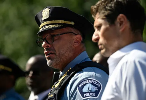 قائد شرطة مينيابوليس يتحدث في مؤتمر صحفي بعد حادث إطلاق نار في كنيسة، مع ظهور مسؤولين آخرين في الخلفية.