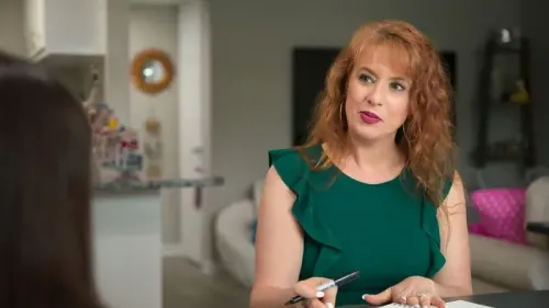 امرأة ذات شعر بني ومجعد ترتدي فستانًا أخضر، تتحدث مع شخص آخر في بيئة داخلية مريحة، تعكس تجربة التواصل الاجتماعي للأشخاص ذوي التوحد.