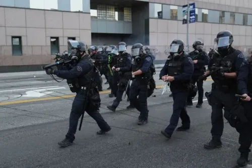 عناصر الشرطة يرتدون معدات مكافحة الشغب أثناء تدخلهم في الاحتجاجات وسط مدينة لوس أنجلوس، وسط توتر متزايد وحالة طوارئ محلية.