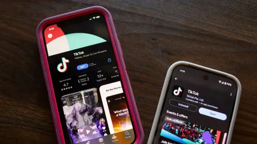 بين هاتفين محمولين يعرضان تطبيق تيك توك، يبرز أهمية التطبيق في النقاشات التجارية بين الولايات المتحدة والصين.