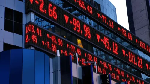 شاشة تعرض أسعار الأسهم باللون الأحمر، مع تراجع مؤشرات السوق الأمريكية مثل ستاندرد آند بورز 500، مما يعكس تقلبات السوق الحالية.