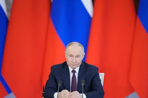 بوتين يجلس أمام ميكروفون في مؤتمر صحفي، مع خلفية من الأعلام الروسية، معبراً عن استعداده لمناقشة العلاقات الأمريكية الروسية.