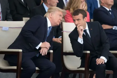 دونالد ترامب وإيمانويل ماكرون يتبادلان الحديث أثناء حدث رسمي، مع خلفية من الحضور، مما يعكس التعاون بين الولايات المتحدة وفرنسا.