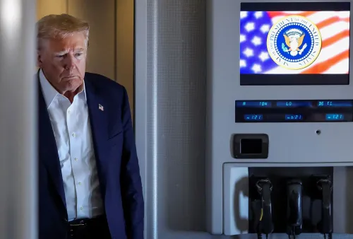 ترامب يبدو عابسًا في الطائرة، بينما تظهر الشاشة خلفه شعار الرئاسة الأمريكية وعلم الولايات المتحدة، مما يعكس حالة التوتر السياسي.