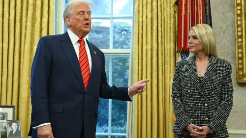 دونالد ترامب يتحدث في المكتب البيضاوي، بينما تستمع إليه مستشارة ترتدي ملابس رسمية، وسط أجواء رسمية.