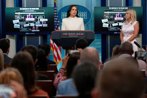 تظهر تولسي غابارد خلال مؤتمر صحفي، حيث تعرض معلومات حول تدخل روسيا في انتخابات 2016، مع رسومات بيانية خلفها توضح الادعاءات.