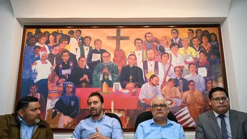 اجتماع لمدافعين عن حقوق الإنسان أمام لوحة جدارية تمثل شخصيات تاريخية، تعكس التحديات التي تواجهها منظمات المجتمع المدني في السلفادور.