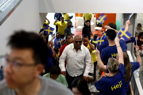 احتفال حاشد في افتتاح متجر IKEA الجديد في أوكلاند، حيث يحمل المتسوقون الأعلام السويدية ويستعدون للدخول.