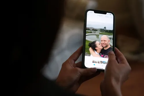 صورة لامرأة ورجل يبتسمان معًا في لقطة سيلفي، يظهران في مكان خارجي جميل مع خلفية طبيعية ومعمارية.