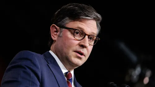 رجل يرتدي بدلة زرقاء ونظارات، يتحدث بجدية في مؤتمر صحفي حول قضايا الميزانية والاعتمادات في الكونغرس.