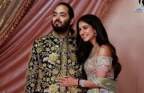 صورة لـ Anant Ambani وزوجته في حفل زفافهما، حيث يعبران عن الفرح في أجواء احتفالية، مع تفاصيل ملابس تقليدية مزخرفة.