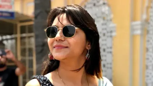 مدونة سفر هندية ترتدي نظارات شمسية، مبتسمة في مكان عام، وسط تصاعد التوترات بين الهند وباكستان بعد اعتقالها للاشتباه في التجسس.