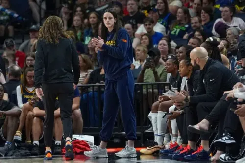 كيتلين كلارك، نجمة كرة السلة، تشاهد مباراة فريق إنديانا فيفر من على مقاعد البدلاء بعد تعرّضها لإصابة، بينما يحتفل الفريق بالفوز.