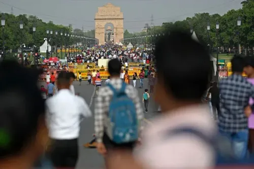 مشهد حيوي لشارع مزدحم في الهند، حيث يتجمع الناس أمام نصب الهند، مما يعكس تأثير النظام الطبقي على الحياة اليومية.