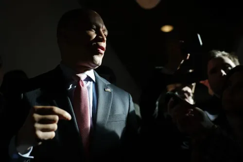 صورة لزعيم الأقلية الديمقراطية حكيم جيفريز يتحدث وسط مجموعة من الصحفيين، مما يعكس التوترات داخل الحزب حول عزل ترامب.