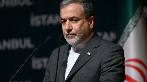 عباس عراقتشي، وزير الخارجية الإيراني، يتحدث في قمة بريكس في البرازيل، مع خلفية تتضمن العلم الإيراني، معبراً عن قلقه بشأن الهجمات على إيران.