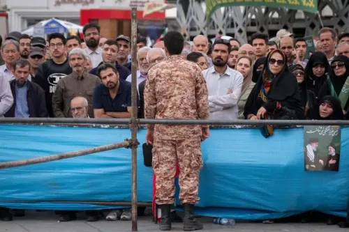 حشد من الناس يتابعون خطاباً من رجل يرتدي زي القوات المسلحة، في سياق حديث حول الإعدامات ضد أعضاء تنظيم داعش في إيران.