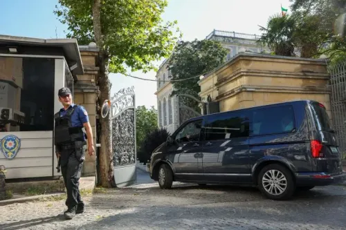 دبلوماسي إيراني يرتدي سترة واقية يقف خارج مبنى أثناء وصول سيارة، في سياق محادثات نووية مع القوى الأوروبية في إسطنبول.