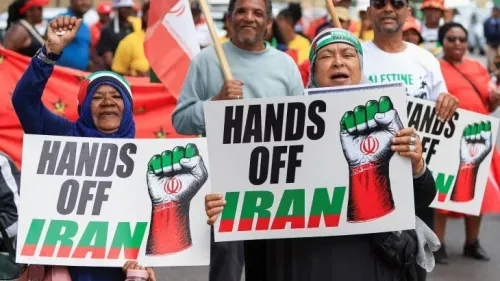 محتجون يحملون لافتات تعبر عن دعمهم لإيران، مع شعارات تدعو إلى عدم التدخل في شؤونها، في سياق الاحتجاجات ضد الحرس الثوري الإيراني.