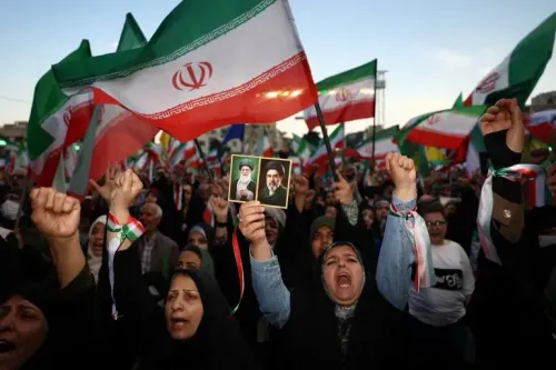 حشود من المتظاهرين الإيرانيين يحملون الأعلام الوطنية وصور القادة، معبرين عن دعمهم في سياق التوترات الإقليمية المتصاعدة.
