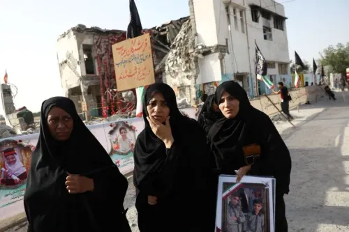 نساء يرتدين الحجاب يقفن أمام مبانٍ مدمّرة، يحملن صورًا لأحبائهن، في سياق الاحتجاجات على الأوضاع الإنسانية في المنطقة.