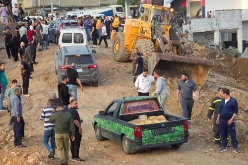 احتفالات في لبنان بعد دخول وقف إطلاق النار حيز التنفيذ، مع تجمع حشود من الناس والمركبات في الشوارع، وآليات تعمل في الخلفية.