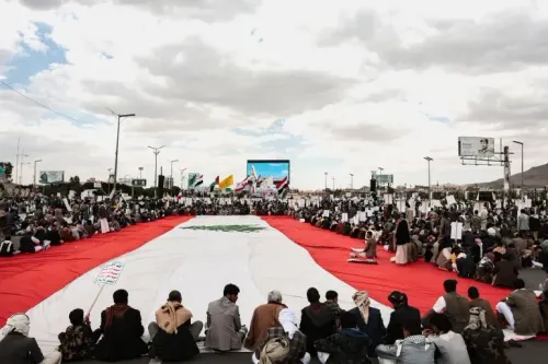 تجمع حاشد في صنعاء يحمل علم لبنان، مع لافتات تعبر عن التضامن، وسط أجواء سياسية متوترة في المنطقة.