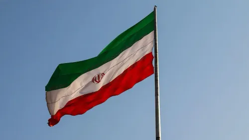 علم إيران يرفرف في السماء، يمثل قضايا حقوق الإنسان والاحتجاجات ضد قوانين الحجاب القاسية في البلاد.