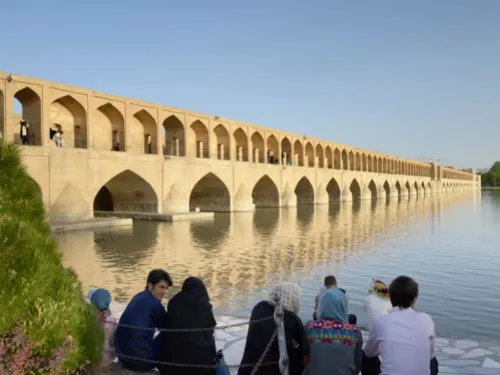 جسر "سي وسه بل" التاريخي في أصفهان، ينعكس في مياه نهر زاينده رود، حيث يعكس تأثير أزمة المياه على المعالم الثقافية.