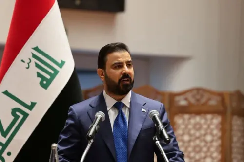 علي الزيدي رئيس الوزراء العراقي يتحدث رسمياً أمام علم العراق استعداداً لزيارة واشنطن لتعزيز التعاون في قطاع النفط والغاز.
