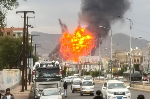 غارة جوية إسرائيلية على صنعاء، تظهر انفجارًا كبيرًا ودخانًا كثيفًا يتصاعد، مع حركة المرور في الشارع.