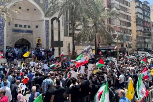 تجمع حشود من المتظاهرين في بيروت حاملين الأعلام واللافتات دعماً لإيران، أمام مسجد خلال صلاة الجمعة.