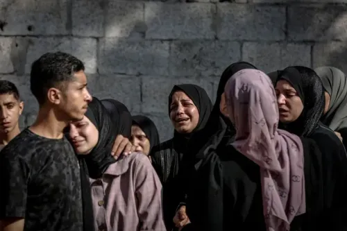 نساء وأطفال فلسطينيون يبكون بحزن في غزة بعد تصاعد العنف والتهجير، وسط دمار خلفته الغارات الجوية الإسرائيلية.