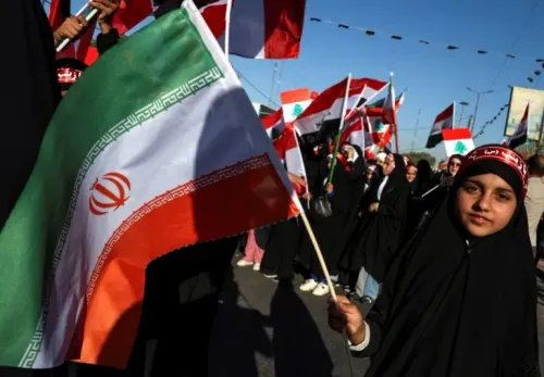 طفلة ترتدي الحجاب وتحمل علم إيران، وسط حشود من المتظاهرين الذين يحملون أعلامًا لبنانية وإيرانية في مسيرة دعم.