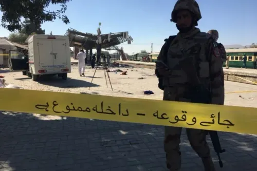 موقع حطام في محطة قطار ببلوچستان، مع وجود ضباط أمن يراقبون المنطقة. تشير الأشرطة إلى منطقة محظورة، مما يعكس حالة التوتر الأمني في المنطقة.