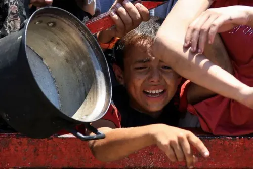 طفل فلسطيني يبكي في محاولة للحصول على الطعام، وسط أزمة إنسانية متفاقمة في غزة بسبب نقص المساعدات الغذائية.