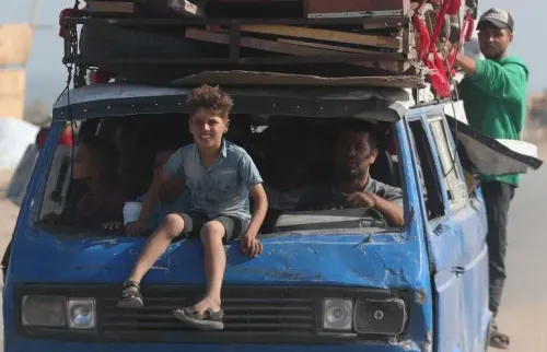 عائلة فلسطينية تفر من مدينة غزة في سيارة قديمة، حيث يجلس طفل على حافة السقف بينما يتجمع أفراد آخرون داخل السيارة.