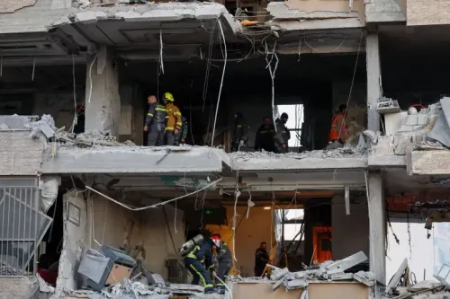 دمار واسع في مبنى سكني ببيروت بعد غارة إسرائيلية، مع وجود فرق الإنقاذ في الموقع. الهجوم أسفر عن مقتل وإصابة العديد.