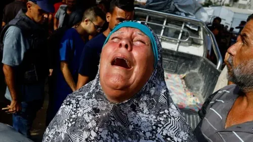 امرأة تبكي بحرقة وسط تجمع من الناس في غزة بعد الهجوم الإسرائيلي، تعبيرًا عن الحزن لفقدان عائلتها.