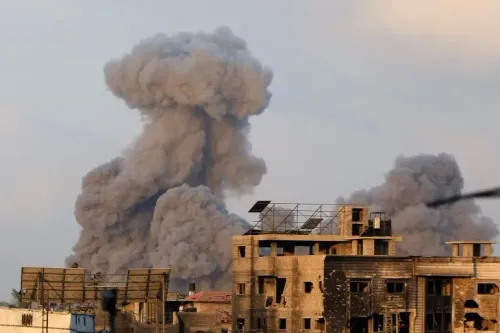 تصاعد سحب من الدخان الكثيف فوق المباني المدمرة في غزة بعد غارة جوية، مما يعكس تصاعد العنف والدمار في المنطقة.