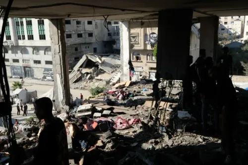أنقاض مبنى مدمر في حي النصر بغزة بعد غارة إسرائيلية، مع وجود أشخاص وسط الدمار في منطقة مأهولة بالسكان.