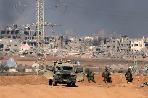 جنود إسرائيليون يتحصنون قرب مركبة عسكرية في منطقة مدمرة بمدينة غزة، مع وجود مبانٍ مهدمة في الخلفية.