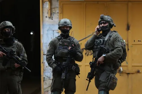 جنود إسرائيليون مدججون بالسلاح يقفون في شارع ضيق، مع خلفية جدران ملونة، في سياق تصعيد التوترات في الضفة الغربية المحتلة.