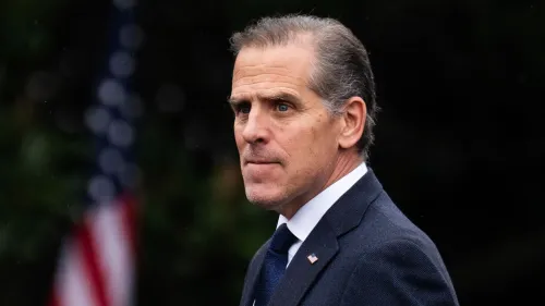 يظهر هانتر بايدن وهو ينظر بجدية، مع العلم الأمريكي في الخلفية، في سياق التحقيقات الجارية حول عائلته.