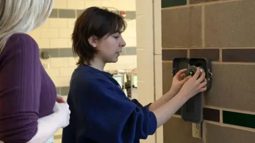 طالبة في مدرسة ويكفيلد الثانوية تقوم بوضع هاتفها في حقيبة مغناطيسية مقفلة، ضمن سياسة جديدة للحد من استخدام الهواتف في الفصول الدراسية.