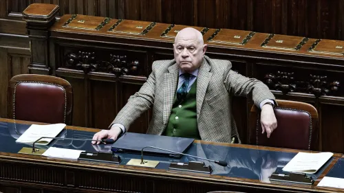 رجل يجلس في البرلمان الإيطالي، يبدو عليه التركيز، محاط بمكتب وأوراق، وسط أجواء رسمية تتعلق بقضية تسليم مواطن إيراني.