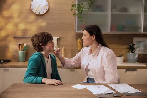 امرأة تعطي لقاح FluMist لطفل في المنزل، مما يبرز إمكانية التطعيم الذاتي في موسم الإنفلونزا.